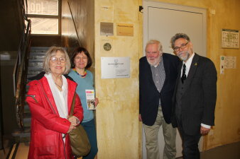 Foto: Spendenverdoppelungsaktion am Erinnerungsort Topf & Söhne © Stadtverwaltung Erfurt/Erinnerungsort Topf & Söhne vier Personen stehen an einer Wand, an dem eine silberfarbene Plakette mit Schriftzug "Bethe-Stiftung" hängt